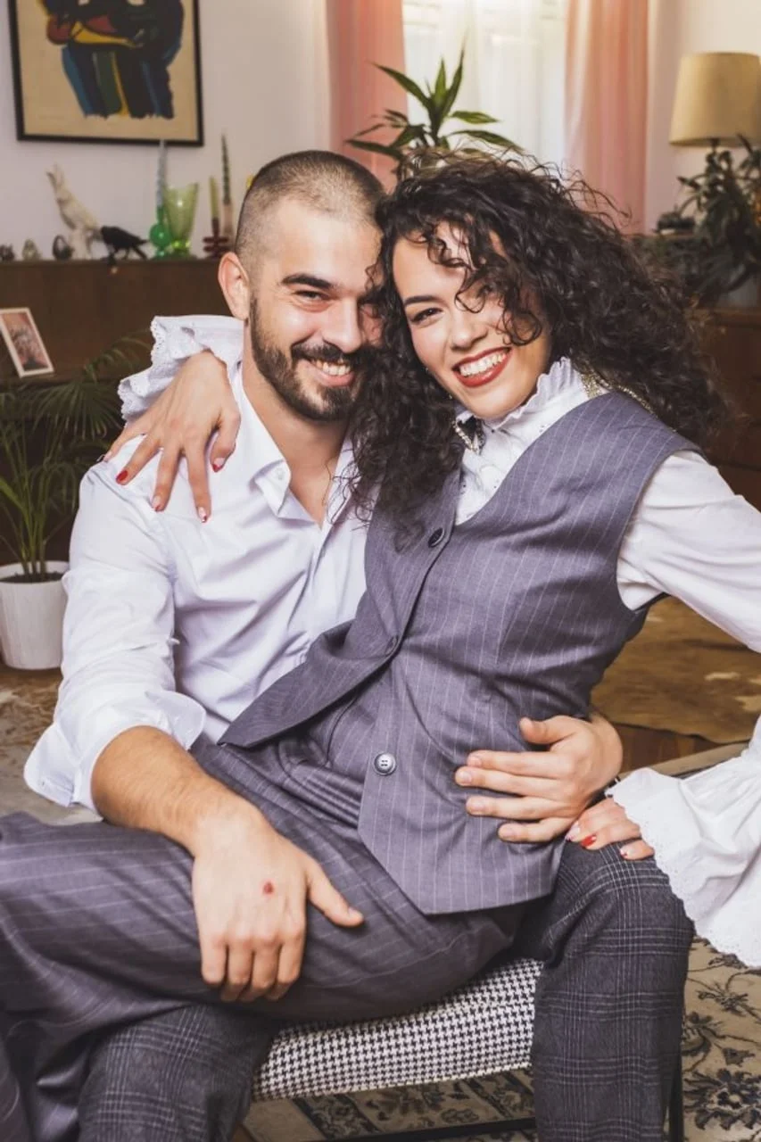 Nasmijana Gina Damjanović sjedi u krilu Marka Bratoša u dnevnom boravku