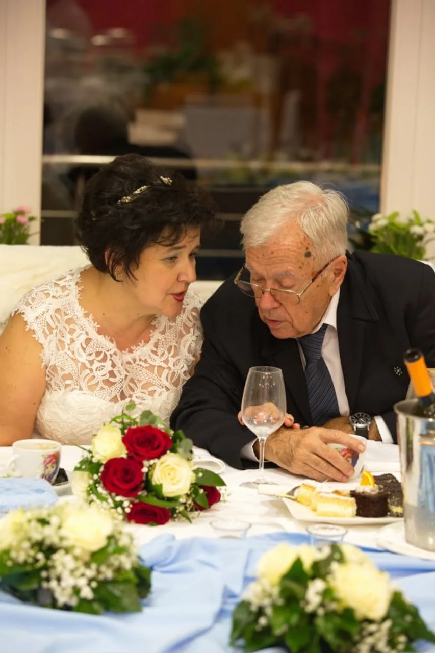 Mladenci za stolom tijekom svadbene večere razgovaraju