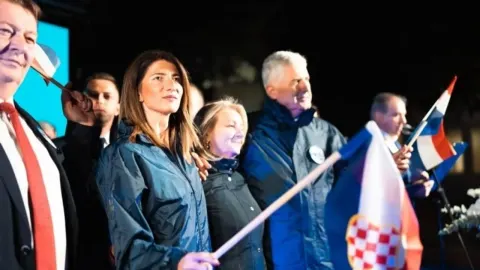 Dragan Čović i članovi HDZ-a BiH s hrvatskim zastavama na otvorenom.