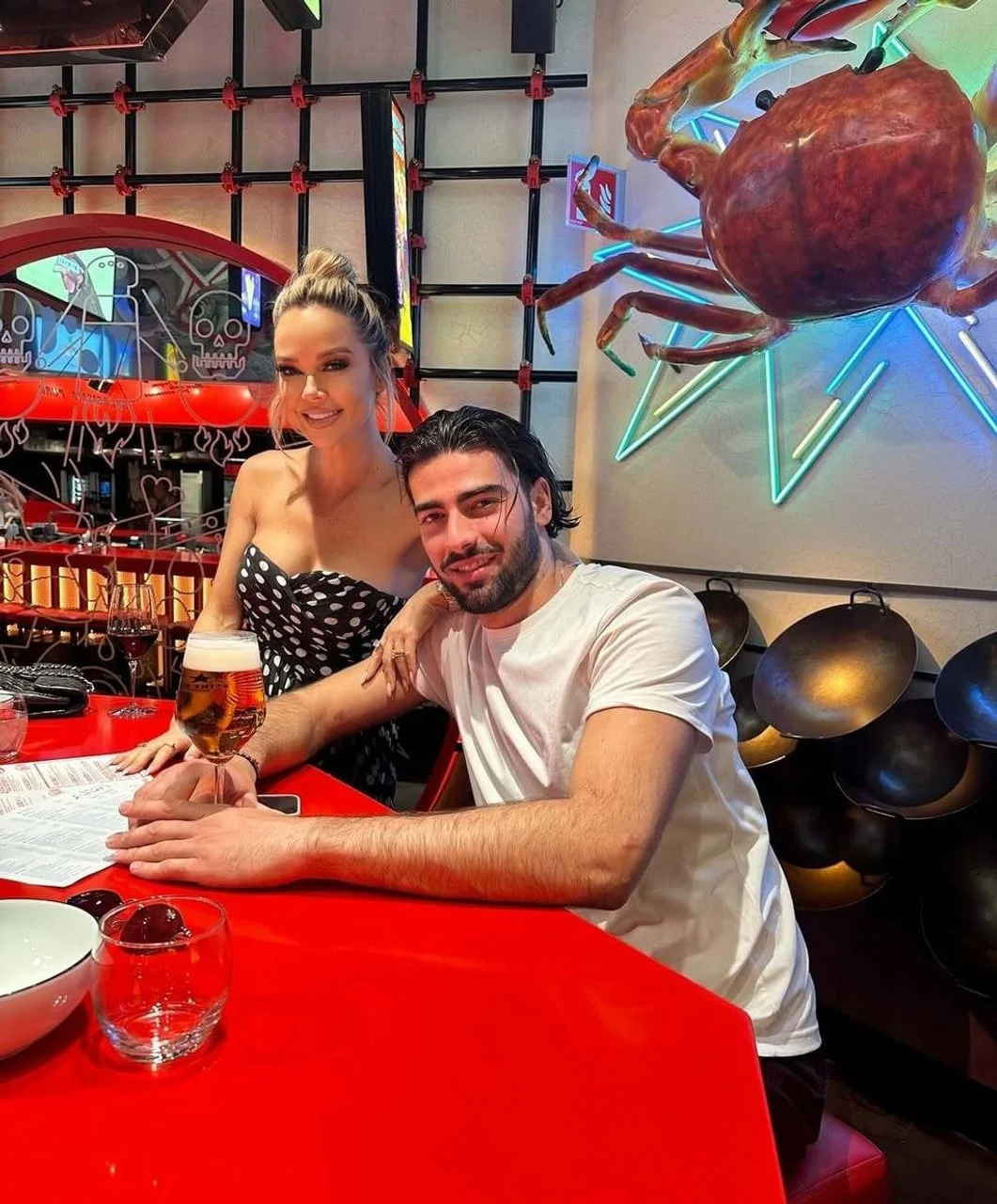 Par pozira za stolom u modernom interijeru s dekoracijom raka