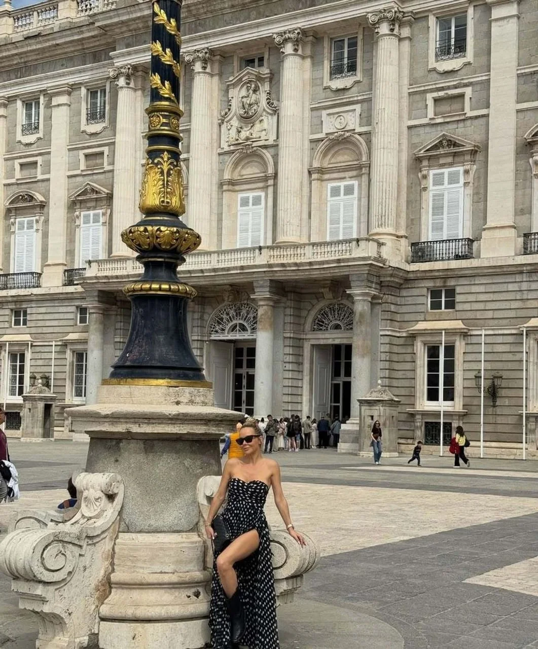 Maja Šuput u crnoj haljini s točkicama ispred povijesne zgrade