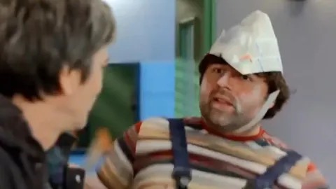 Glumac Branko Janković kao lik Fufa s papirnatom kapom na glavi.