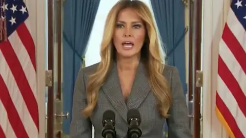 Melania Trump stoji za govornicom ispred američkih zastava