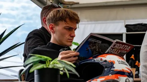 Toni Fruk u trkaćem odijelu pregledava vodič za Croatia Rally.