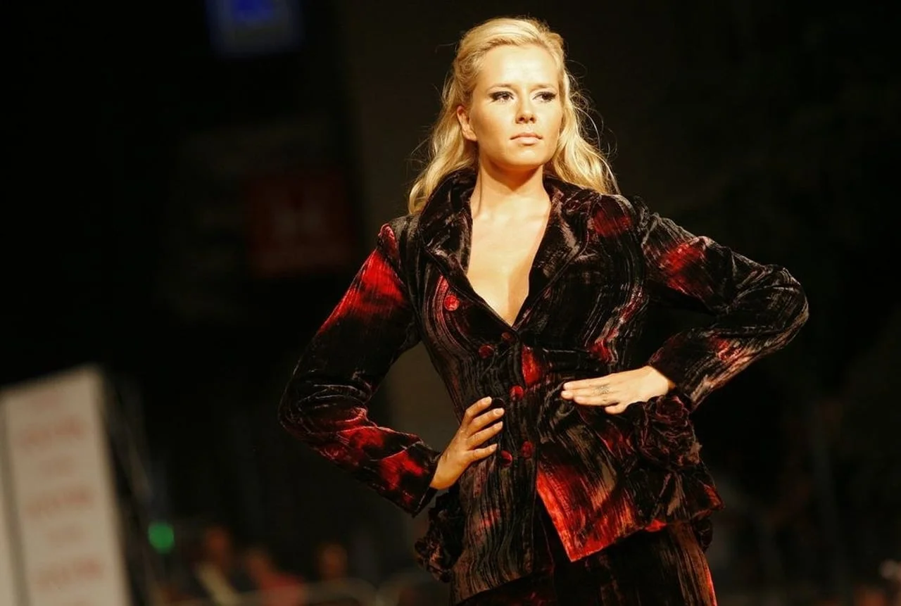 Žena modnom pistom hoda u crvenom baršunastom odijelu