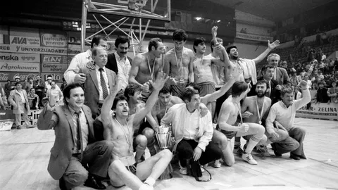 Crno-bijela fotografija košarkaša Zadra koji slave naslov prvaka uz pobjednički pehar.