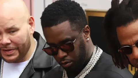 Sean Diddy Combs s naočalama i debelim srebrnim lancima u krupnom planu.