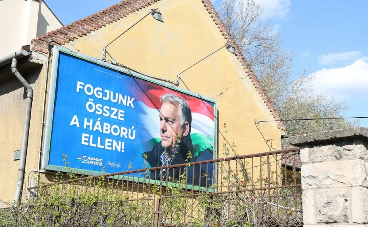 Politički plakat s likom Viktora Orbana na zidu stare zgrade.
