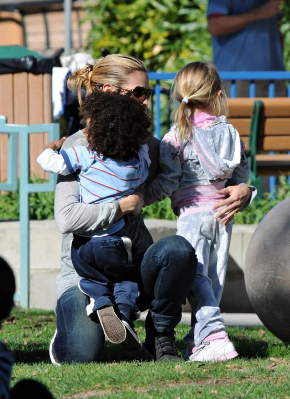 Heidi Klum kleči na travi i grli dvoje djece u parku