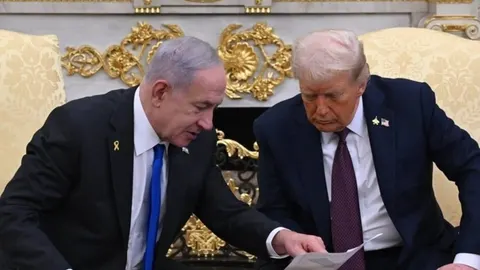 Benjamin Netanyahu i Donald Trump pregledavaju dokumente tijekom sastanka.