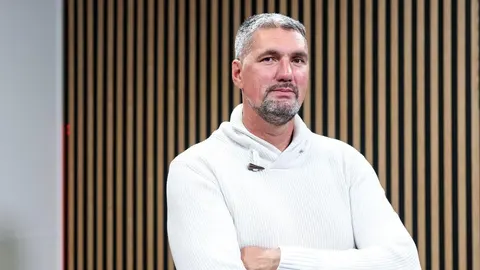 Portret Brune Šundova u bijelom džemperu ispred drvenih letvica