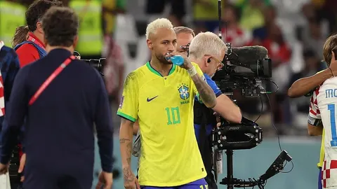 Neymar u žutom dresu Brazila pije vodu na nogometnom terenu nakon utakmice protiv Hrvatske.