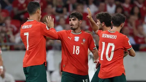 João Neves, Cristiano Ronaldo i suigrači u crvenim dresovima Portugala na terenu.