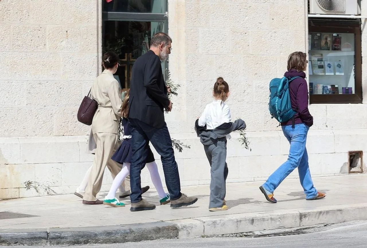 Slaven Bilić u odijelu i trapericama hoda gradom s obitelji noseći maslinove grančice.