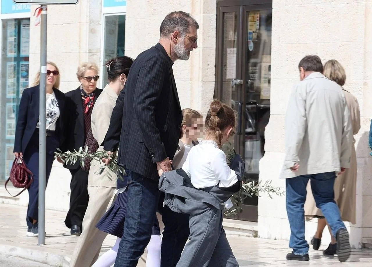 Slaven Bilić drži kćer za ruku dok prolaze gradskom ulicom noseći grančice.