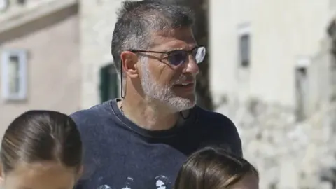 Slaven Bilić s naočalama i sijedom bradom u opuštenom izdanju na otvorenom.