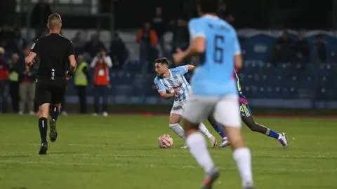 Nogometaši Dubrave i Cibalije u duelu za loptu tijekom večernje utakmice u Zagrebu.