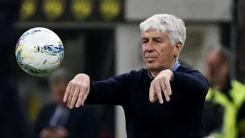 Gian Piero Gasperini gestikulira rukama dok nogometna lopta leti u zraku pokraj njega.