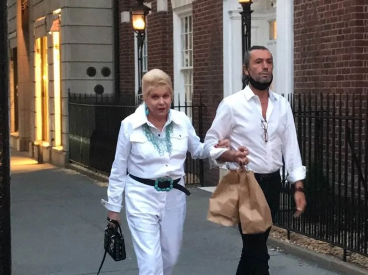 Ivana Trump u bijelom odijelu hoda ulicom uz pratnju