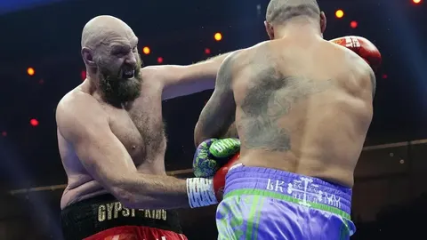 Tyson Fury zadaje udarac protivniku tijekom boksačkog meča u ringu.