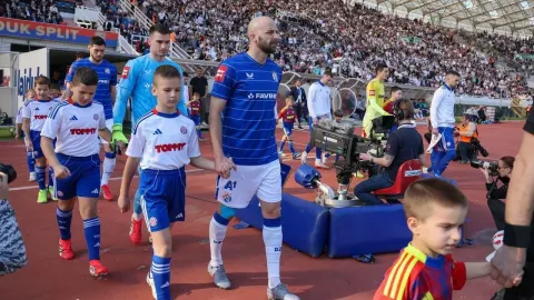 Josip Mišić izlazi na teren stadiona Poljud u pratnji dječaka.