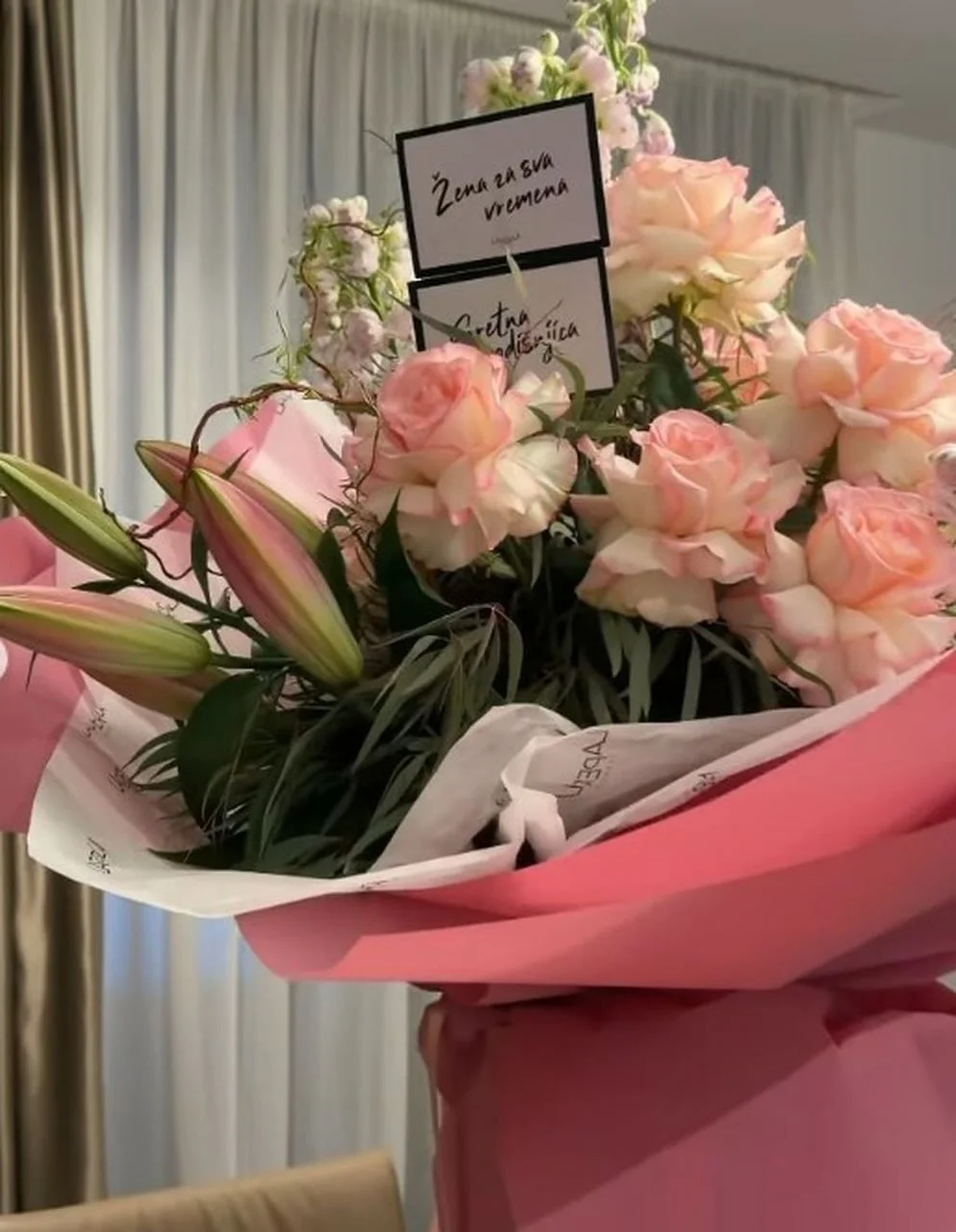 Buket ružičastih ruža i ljiljana s porukom 'Žena za sva vremena'.