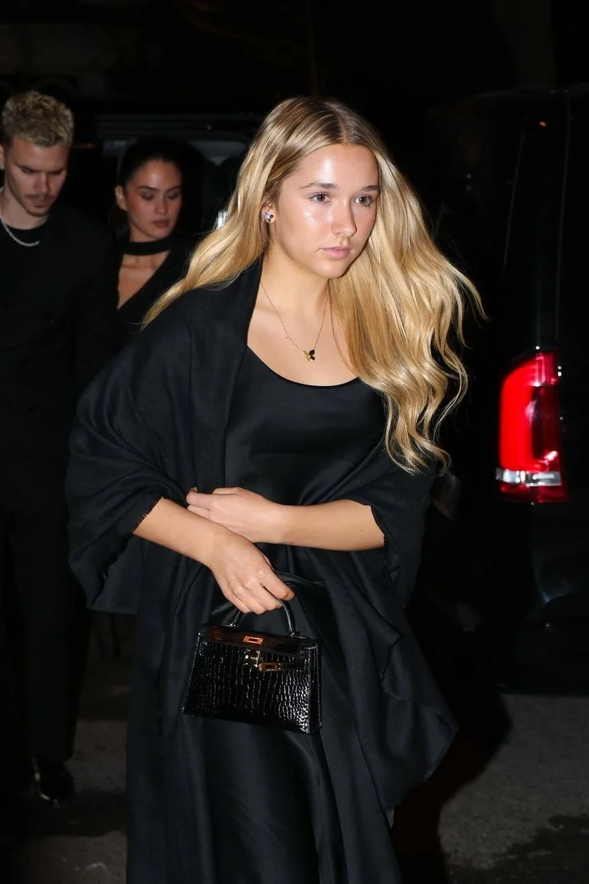 Harper Beckham u crnoj haljini s malom torbicom noću