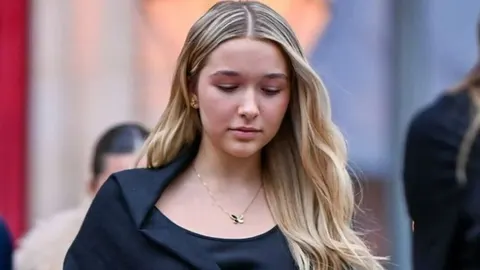 Harper Seven Beckham u crnoj odjeći gleda prema dolje