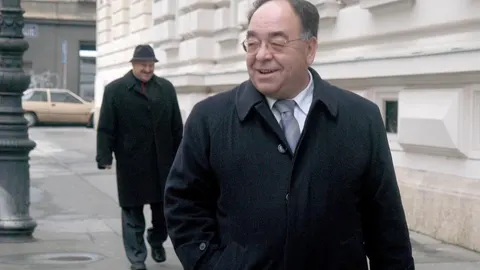 Josip Gucić u tamnom kaputu hoda ulicom ispred sudske zgrade