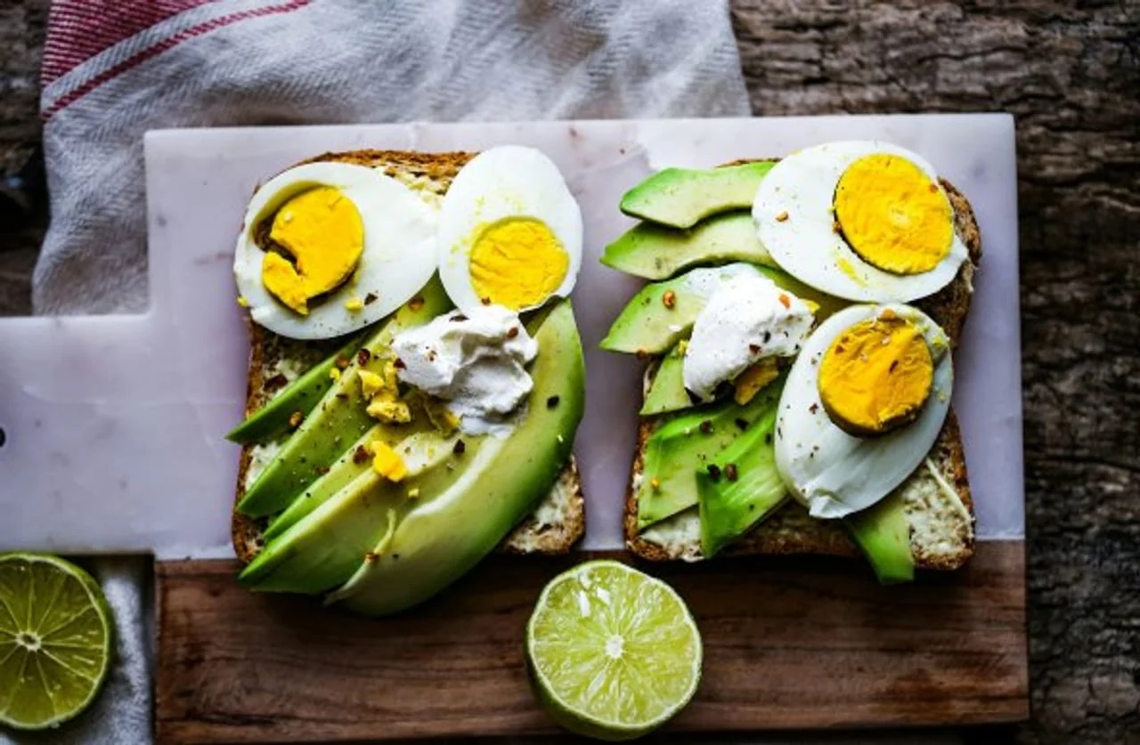 Tost s narezanim avokadom i kuhanim jajima na drvenoj podlozi