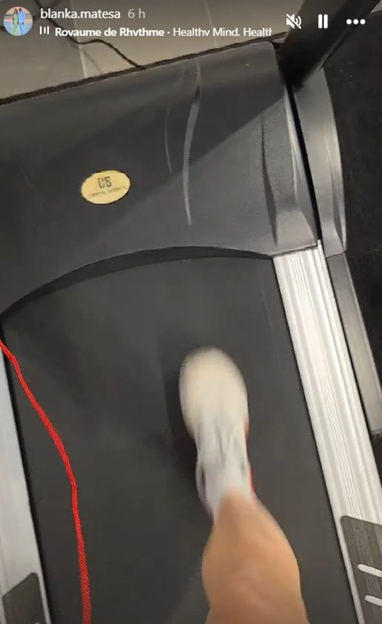 Noga u sportskoj tenisici na traci za trčanje u pokretu