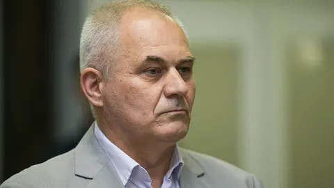 Portret Ivana Rimca u svijetlom odijelu ozbiljnog izraza lica.