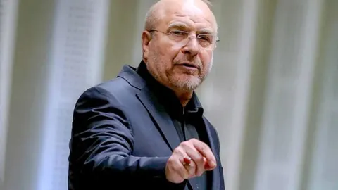 Mohammad Bagher Ghalibaf u tamnom odijelu gestikulira rukom tijekom govora.