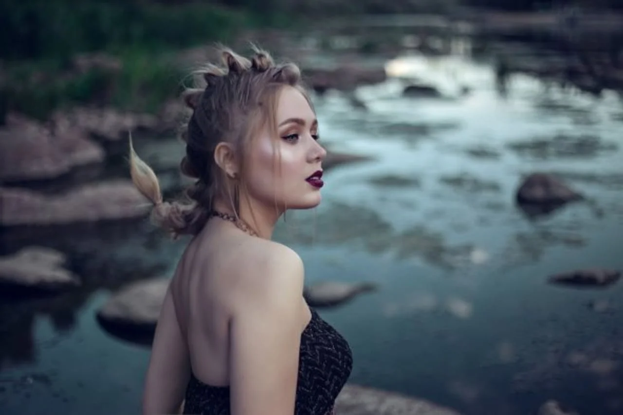 Djevojka s profilom okrenutim prema rijeci i neobičnom frizurom.