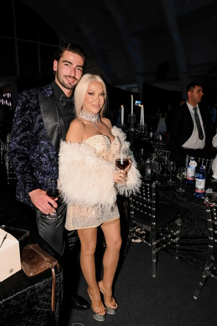 Svečano odjeveni Maja Šuput i Šime Elez na večernjem događaju s čašama vina.