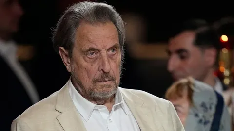 Portret Errola Muska u svijetlom sakou tijekom pravoslavne liturgije u Moskvi.