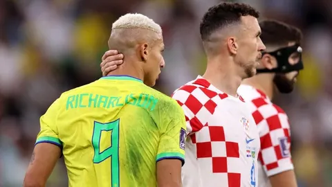 Richarlison s leđa u žutom brazilskom dresu pored hrvatskih reprezentativaca.