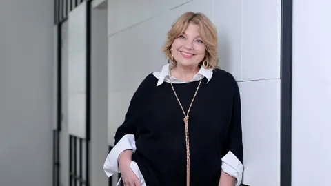 Karmela Vukov-Colić nasmijana pozira u crnoj tunici i bijeloj košulji