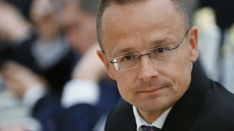 Krupni kadar Petera Szijjarta s naočalama u ozbiljnom izdanju.