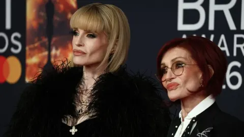 Sharon Osbourne s naglašenim crtama lica na crvenom tepihu.