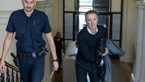 Joško Jeličić u pratnji službene osobe hoda unutar javne ustanove.