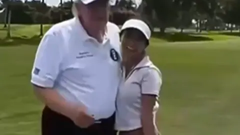 Donald Trump i influencerica Nina Coates stoje na zelenom golf terenu.