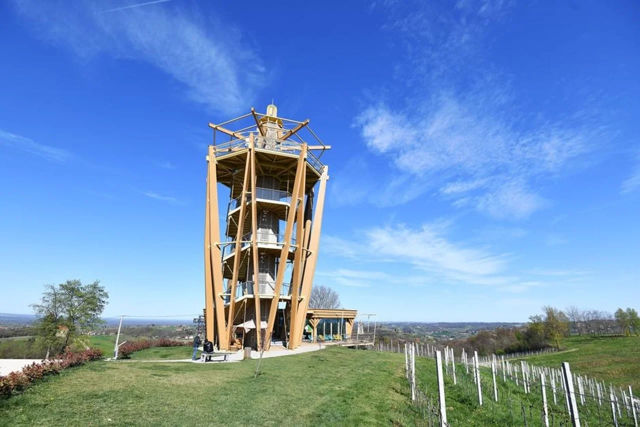 Moderan drveni vidikovac na vrhu brda okružen vinogradima.