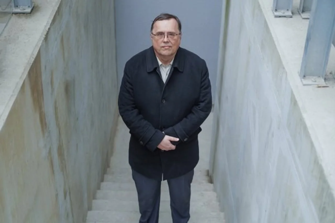 Robert Barić stoji na betonskom stubištu u tamnom kaputu