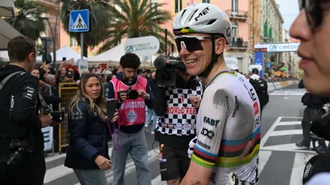 Tadej Pogačar u poderanom biciklističkom dresu nakon utrke okružen kamerama.