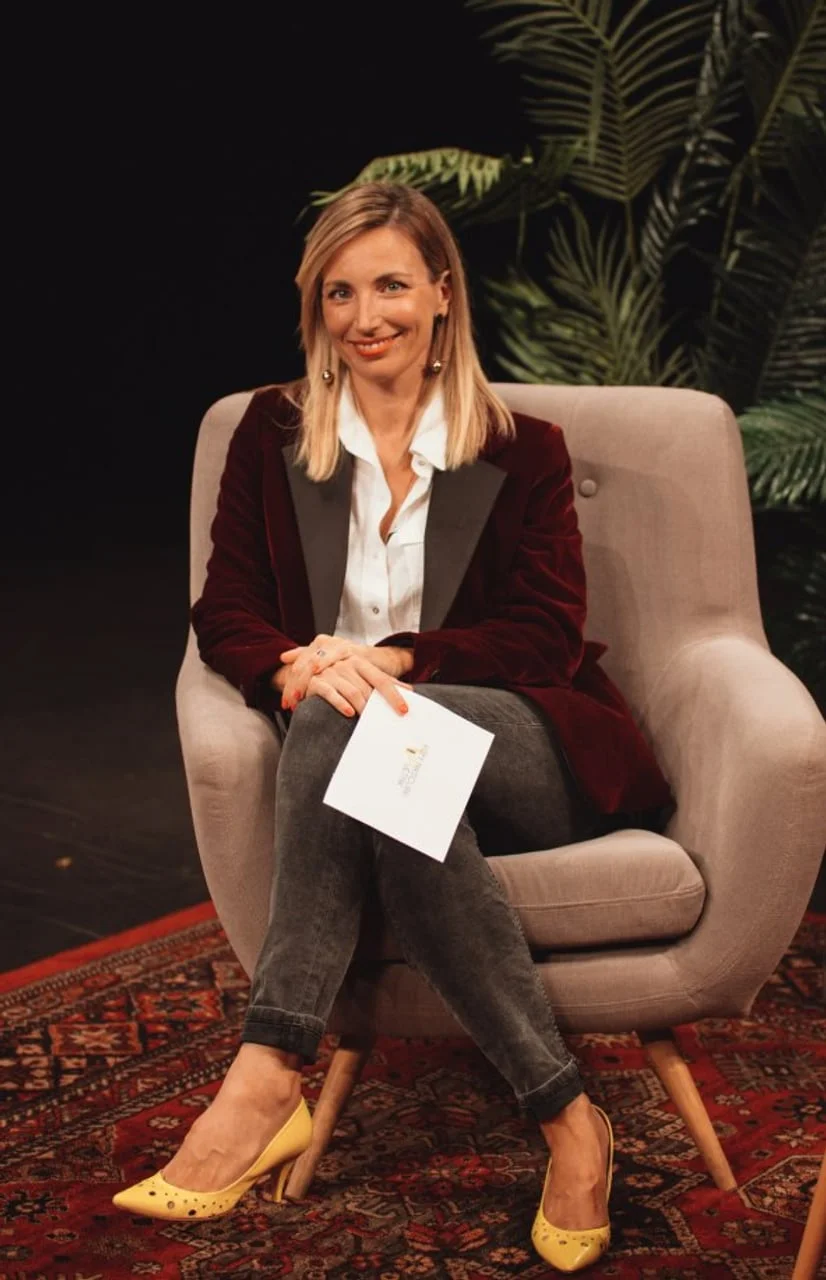 Portret Jelene Makovičić u tamnocrvenom sakou dok drži bilješke u studiju.