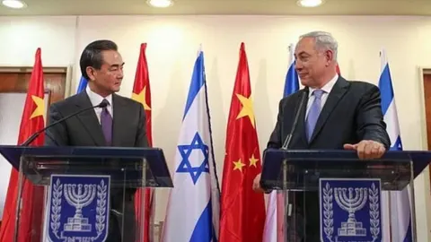 Wang Yi i Benjamin Netanyahu stoje za govornicama ispred zastava Kine i Izraela.