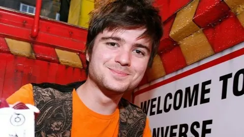 Filip Riđički kao mladi glumac s dužom kosom i narančastom majicom.