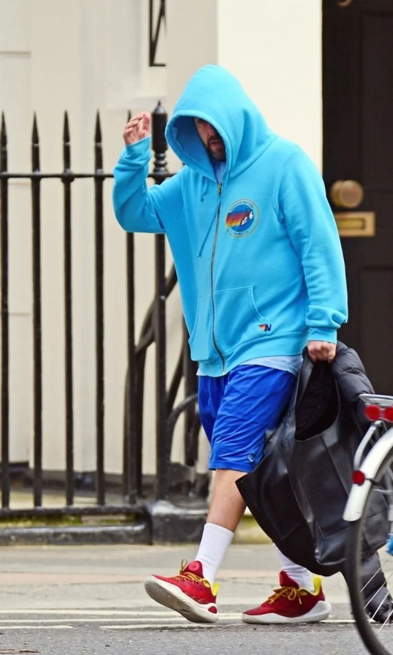 Adam Sandler hoda ulicom u svijetloplavoj majici s kapuljačom