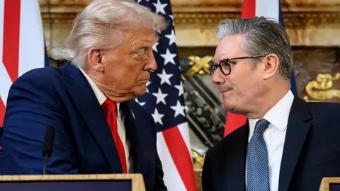 Donald Trump i Keir Starmer razgovaraju ispred američke i britanske zastave.